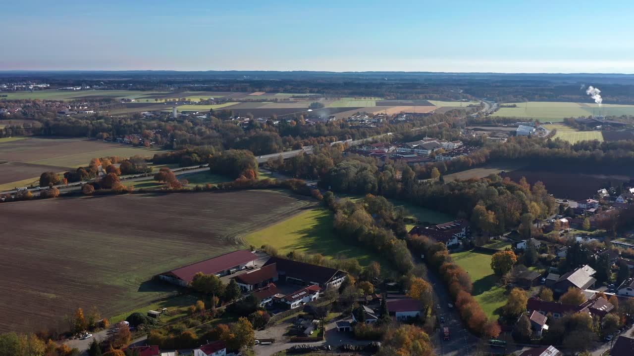suave vuelo hacia atrás sobre una ciudad bávara en la temporada de otoño, una vida idílica junto a árboles y campos de colores otoñales