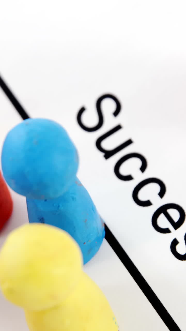 Multicolored figurines on a paper with text success