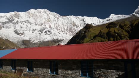 annapurna base camp trekking in nepal with teahouse accommodation and beautiful snowcapped mountains scenery, teahouses and bulidings in a remote village in the himalayas mountains on sunny day
