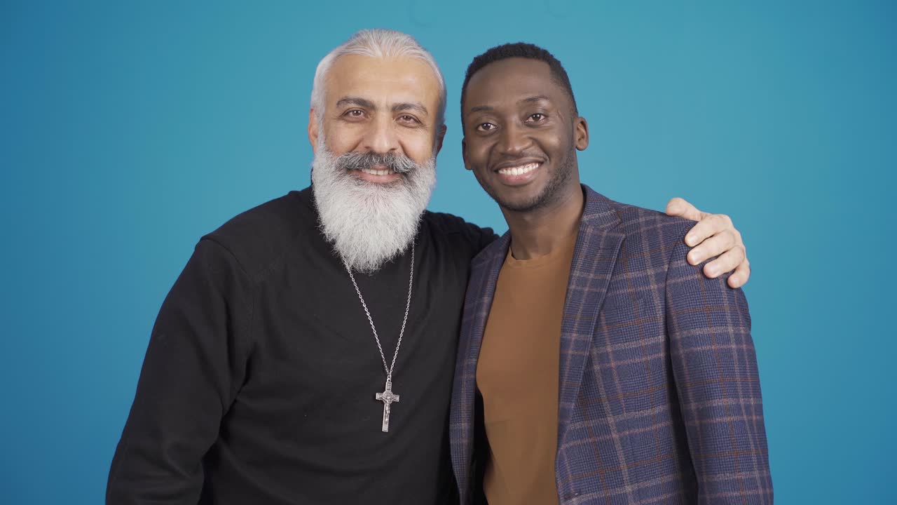 un musulmán africano y un cristiano estrechándose la mano, buenos y sinceros amigos sonriendo a la cámara.