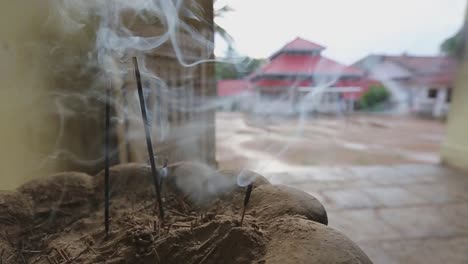 close up static view of smoke coming out of the burning incense in front of an asian buddhist temple in sri lanka