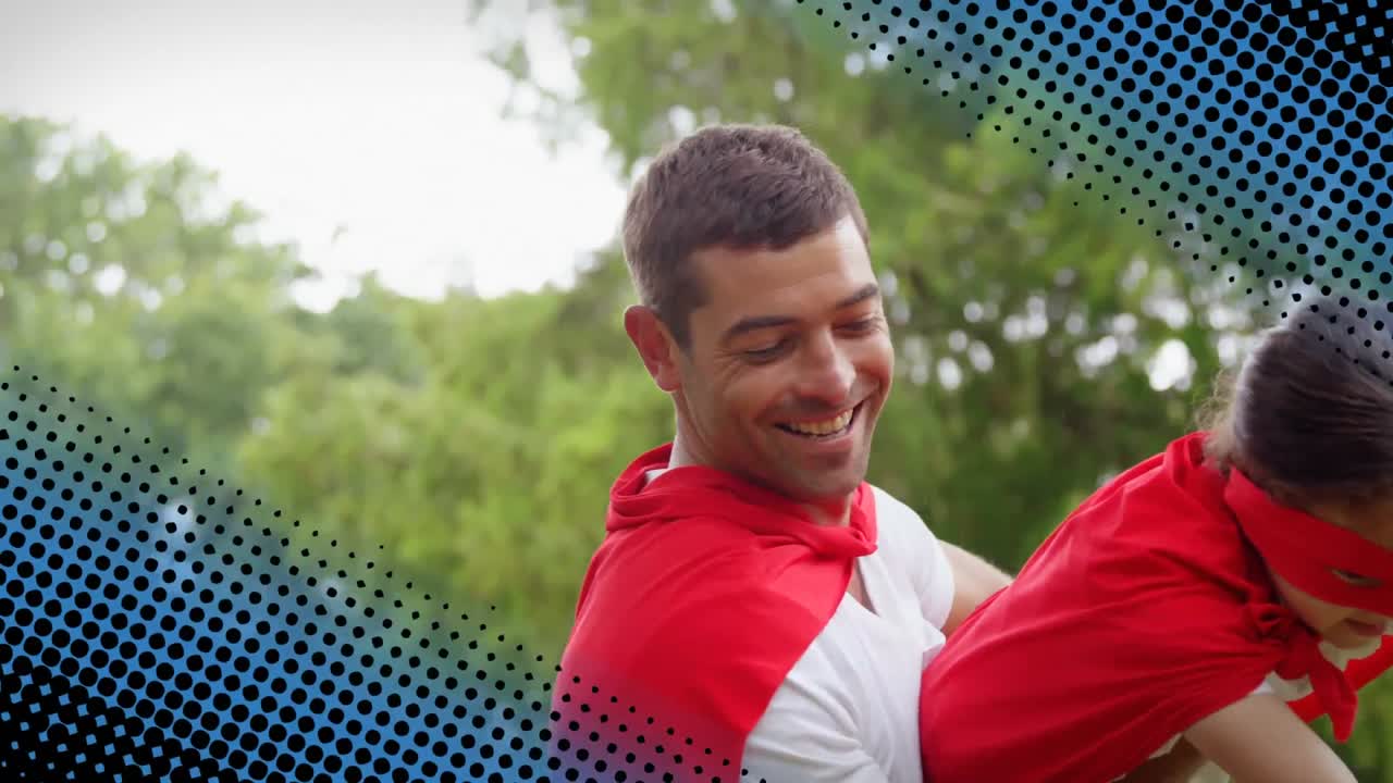 padre cargando a su hija mientras usa trajes de superhéroe