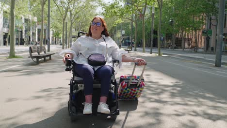 Woman in wheelchair traveling on city street