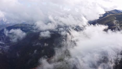 hills covered of clouds and fog in misty morning, epic northern italy aerial