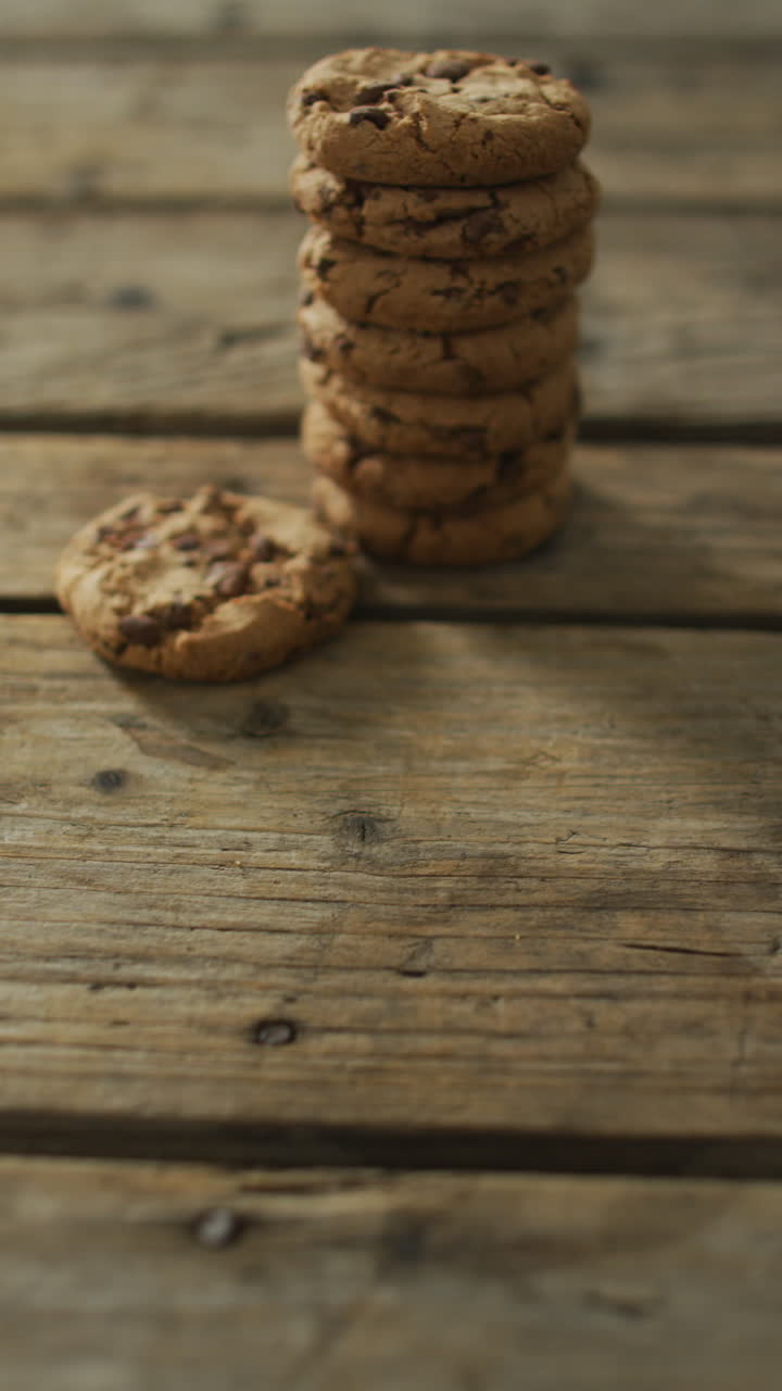 video vertical de una pila de galletas de chispas de chocolate en un fondo de madera