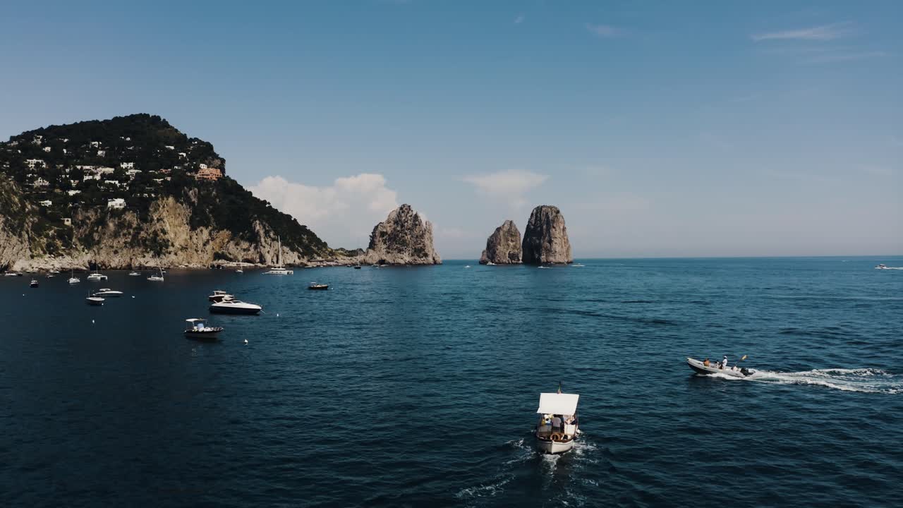 Drone shot of boats traveling along Italy's beautiful shoreline