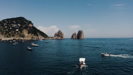 drone shot of boats traveling along italy's beautiful shoreline