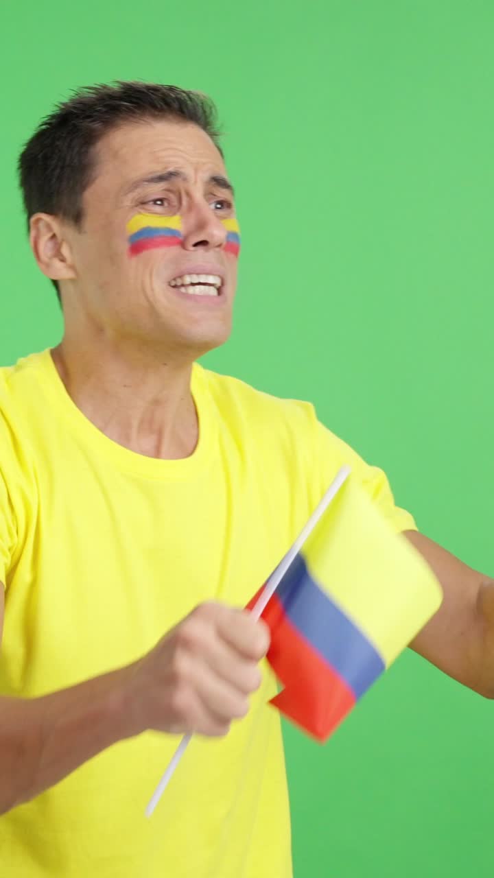 Nervous man cheering for Colombia during a match looking away