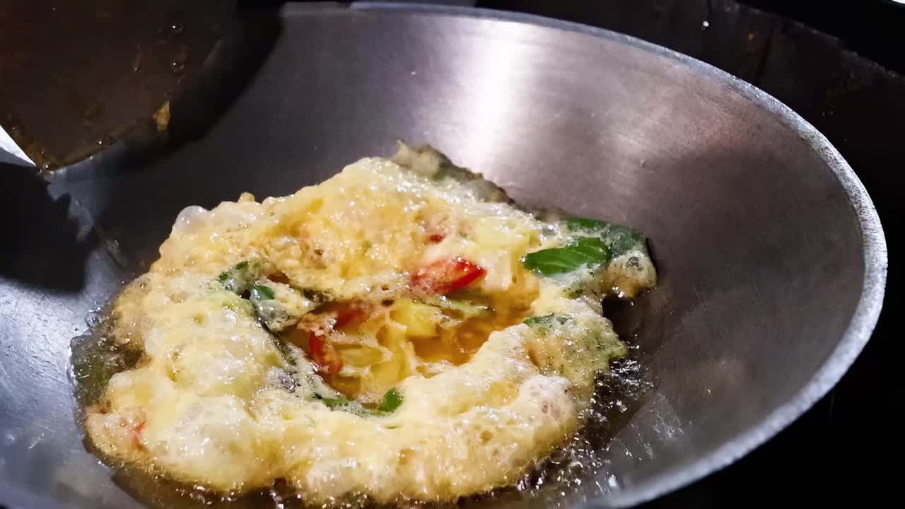 Cooking an omelet in a wok