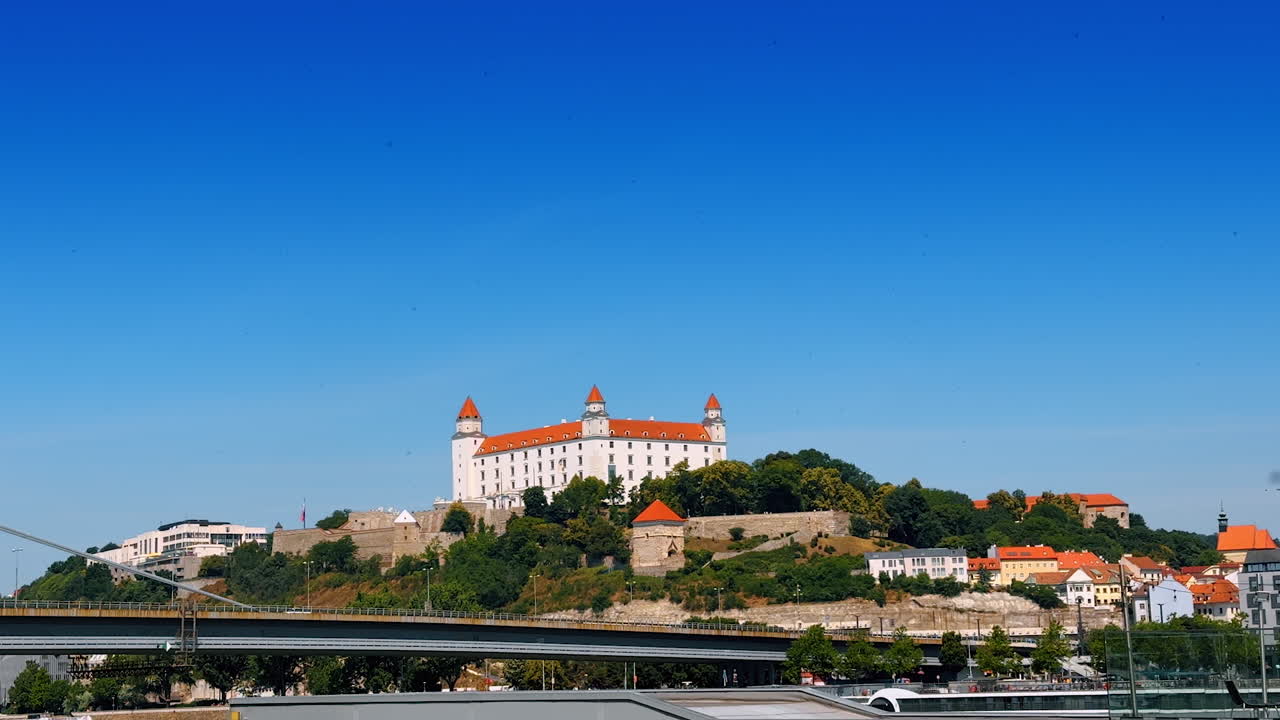 Stunning Bratislava Castle on the hill surrounded by the trees. View on the landmark of Bratislava, Slovakia from across the Danube