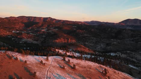 Aerial-View-of-Sunny-Cold-Morning-Above-Snowy-Hills-of-Rocky-Mountain-Range