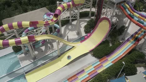 tourists on inner tube waterslide in waterpark on coco cay, bahamas