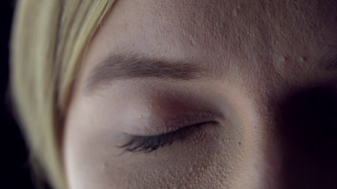 Macro shoot of young woman's closed eye. Calm young blond woman