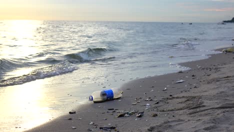 hand keeping plastic bottle garbage in sea