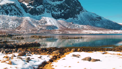 Stunning-cinematic-track-and-tilt-up-shot-of-a-fjord-near-Tromso,-Norway