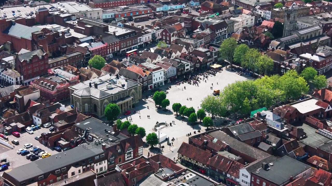 Droneoptagelse fra luften af Salisbury Torv i Wiltshire, der viser den historiske bymidte, Guildhall, butikker, hustage, offentlige plads, fodgængere og omkringliggende gader. Velegnet til temaer om Storbritannien.
