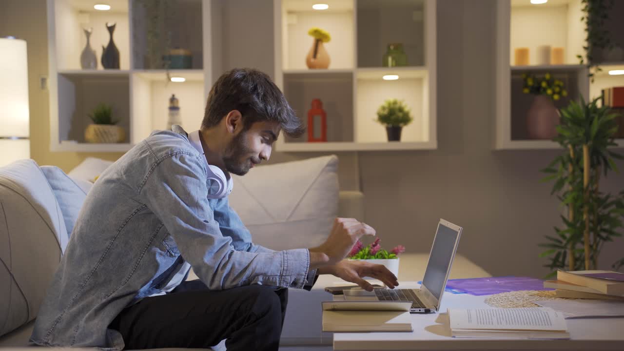 성공한 학생은 집에서 공부하는 동안 미소 짓고 카메라를 쳐다본다.