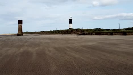 el viento hace olas de arena con dos torres en la distancia