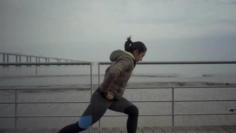 focused hindu woman stretching legs before workout outdoor