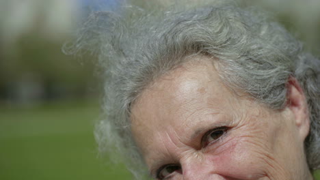 smiling senior woman posing during sunny day.