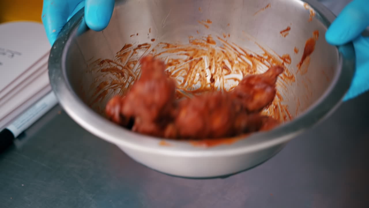 The cook preparing chicken wings for the client in a food truck