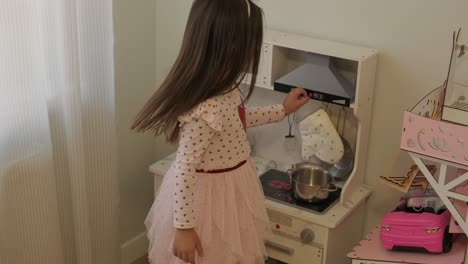 little girl playing in playroom in pretty dress