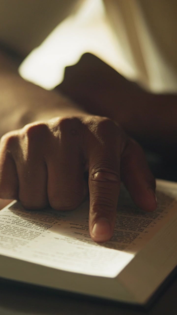 Personne lisant une Bible sainte sous une douce lumière naturelle