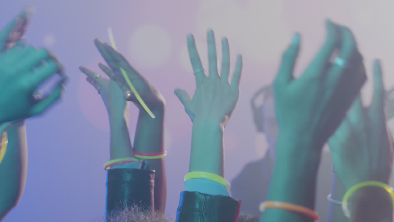 People raising up their arms in the club