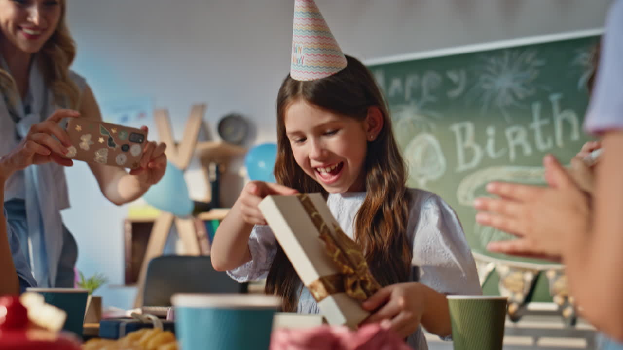 Festeggiamenti in classe per il compleanno di una ragazza che riceve regali