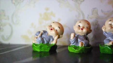 closeup of four smiling monk figurines in peaceful poses. symbol of zen, joy and mindfulness. ideal for decor, spirituality or meditation themes.