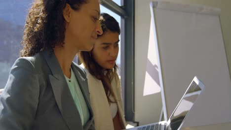 colegas de negocios discutiendo sobre una computadora portátil 4k