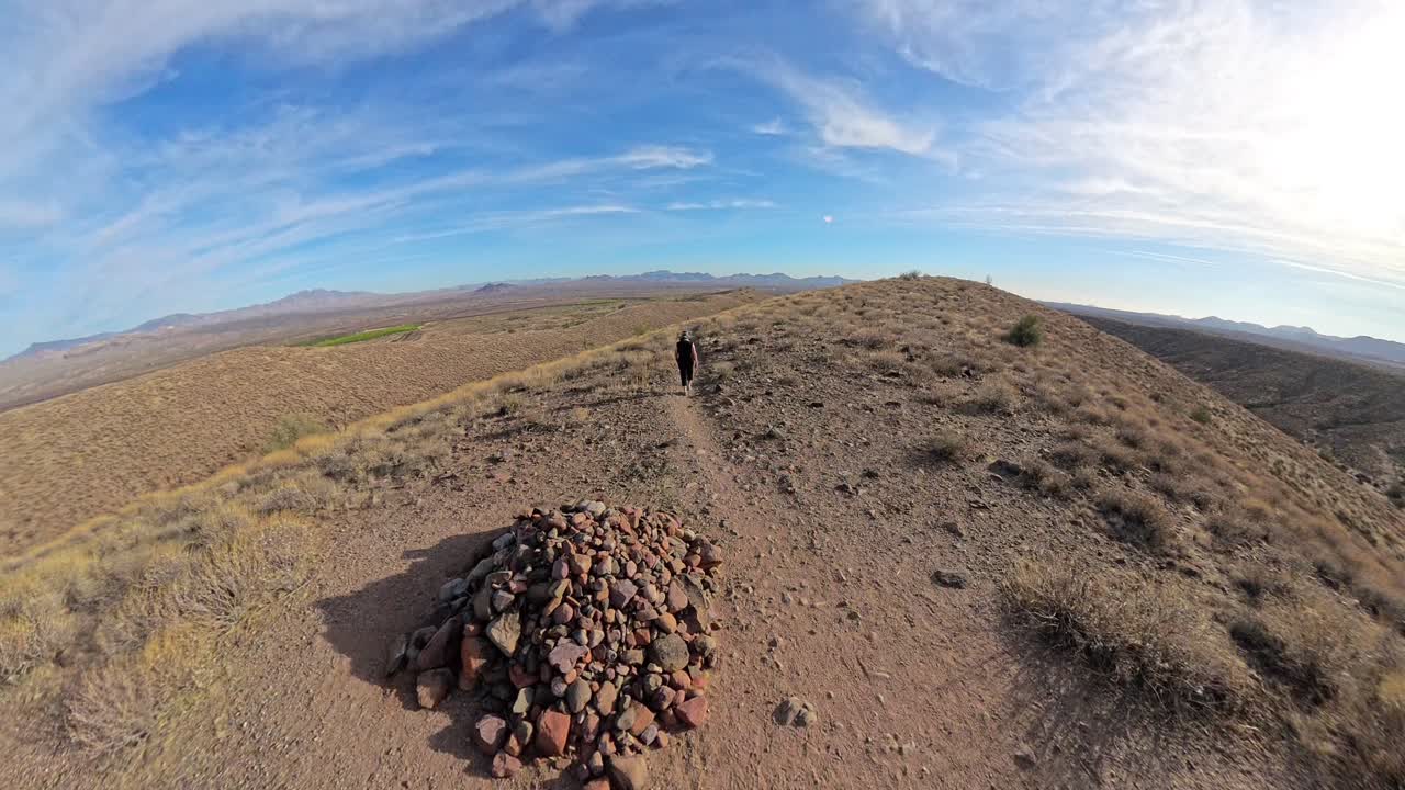 Senior woman walking down hill in the Sonoran Desert.