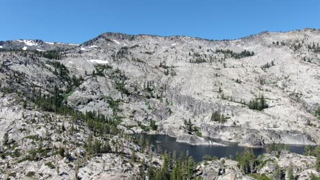 slow cinematic aerial 4k high resolution drone footage of a high altitude alpine lake in desolation wilderness sierra nevada mountains in california shows camping backpacking with friends and family