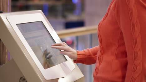 mujer que utiliza un terminal de pago