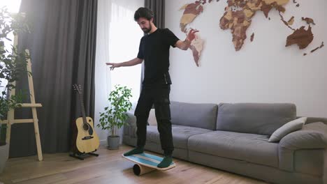 a man holds a balance on the board and pipe at his living room