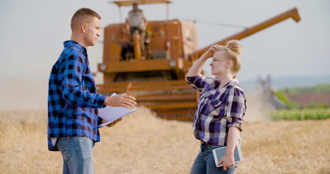 jóvenes agricultores discutiendo en el campo de trigo 2