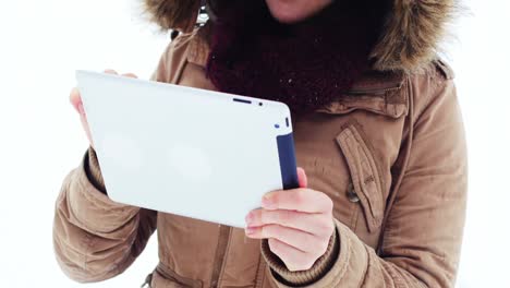 Smiling-woman-in-fur-jacket-using-digital-tablet