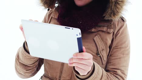 mujer sonriente con chaqueta de piel usando una tableta digital