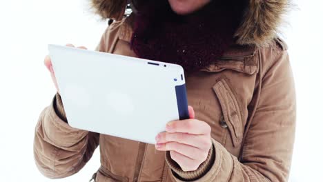 smiling woman in fur jacket using digital tablet