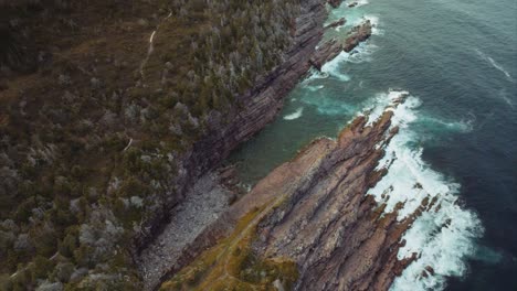 Protected-little-cove-and-rocky-beach-along-rugged-shoreline-with-surf-pounding