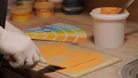 a worker applies a paint sample to a palette for color verification