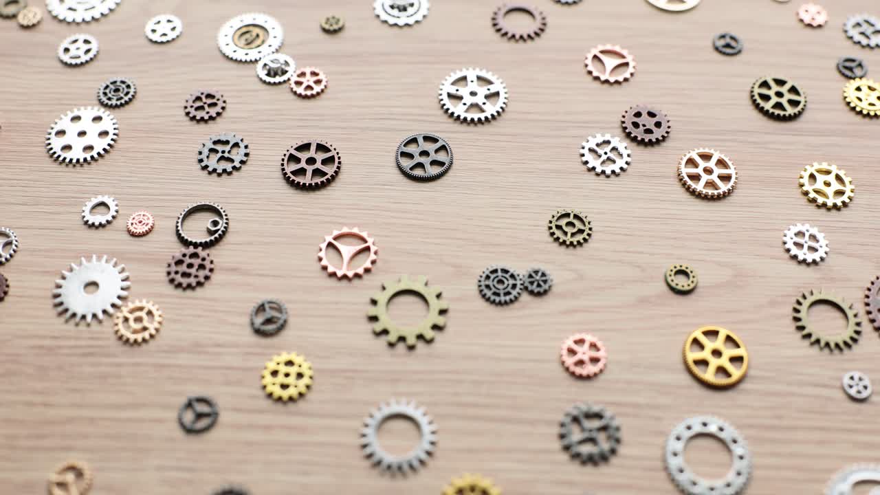 Assorted Metallic Gears Scattered on a Wooden Surface