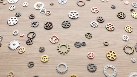 assorted metallic gears scattered on a wooden surface