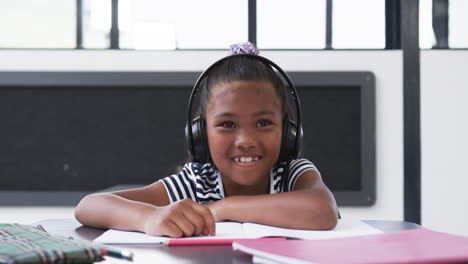 In-a-school-classroom,-a-young-African-American-girl-is-wearing-headphones