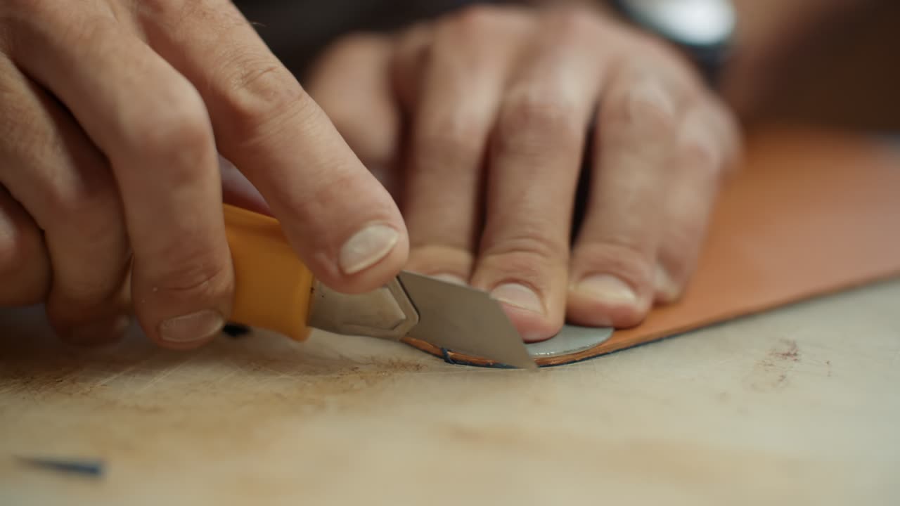 Close-up of Hands Cutting Leather