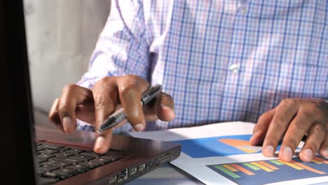 persona de negocios que trabaja en computadora portátil y gráficos