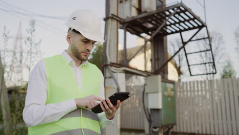 engineer inspecting electrical infrastructure with tablet
