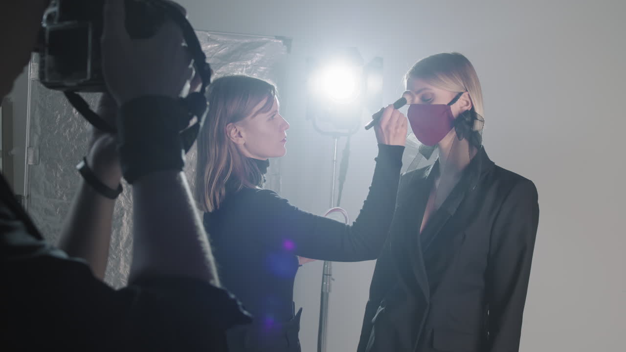 사진 촬영 도중 모델 의 메이크업 을 수정 하는 것