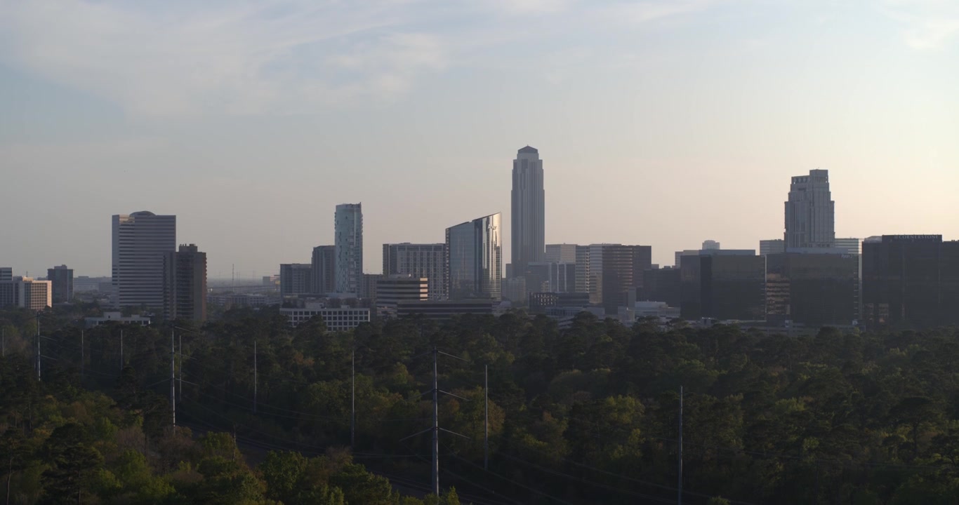 Vista aérea de drone do Distrito Uptown Galleria de Houston durante o pôr do sol, exibindo comércio de luxo, torres de escritórios, hotéis e desenvolvimento urbano moderno sob a luz quente da hora dourada.