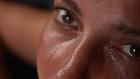 extreme close-up eyes full of tears of a beautiful woman while staring at the camera